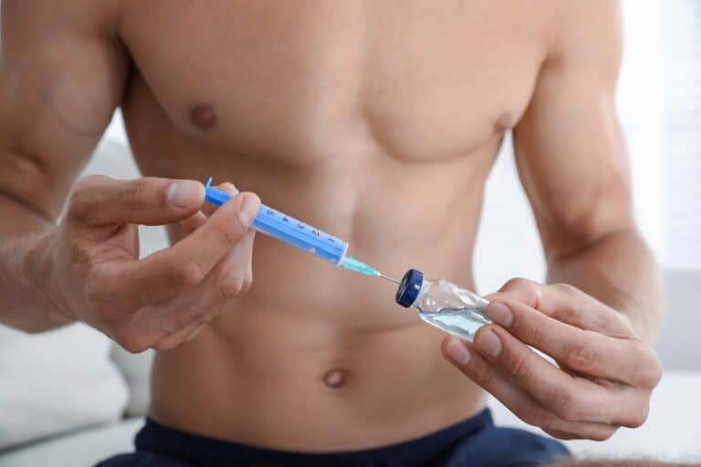 man filling syringe with testosterone drug