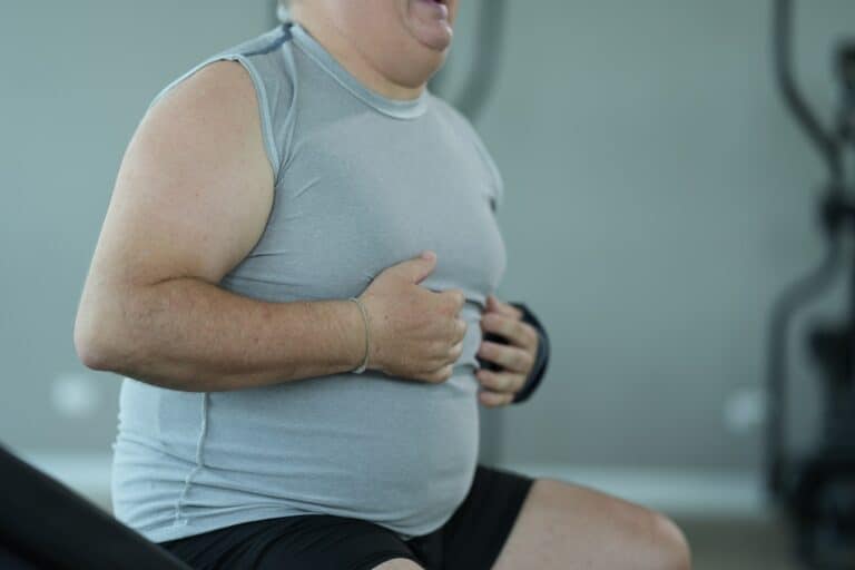 overweight man wearing a gray tank top